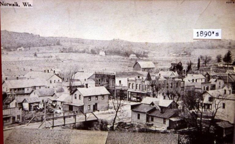 Historic sweeping aerial high-ground view over early Norwalk structures